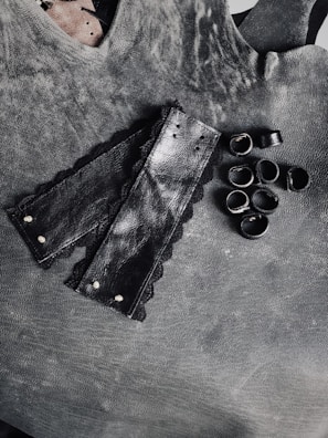 Dark, mysterious setting showcasing a leather harness with subtle gold details.