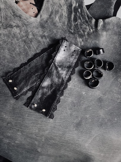 A luxurious leather harness and delicate silk ribbons arranged artfully on a soft velvet surface.