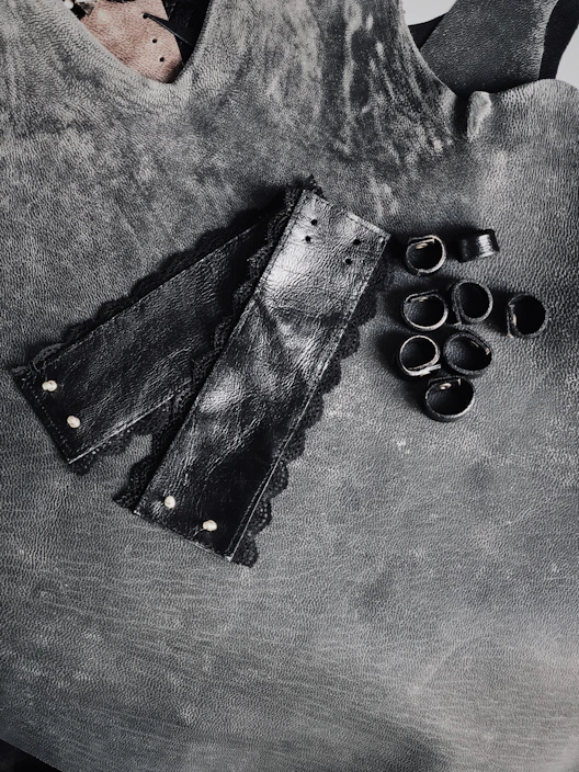 Close-up of elegant leather cuffs with soft padding on a dark velvet background.