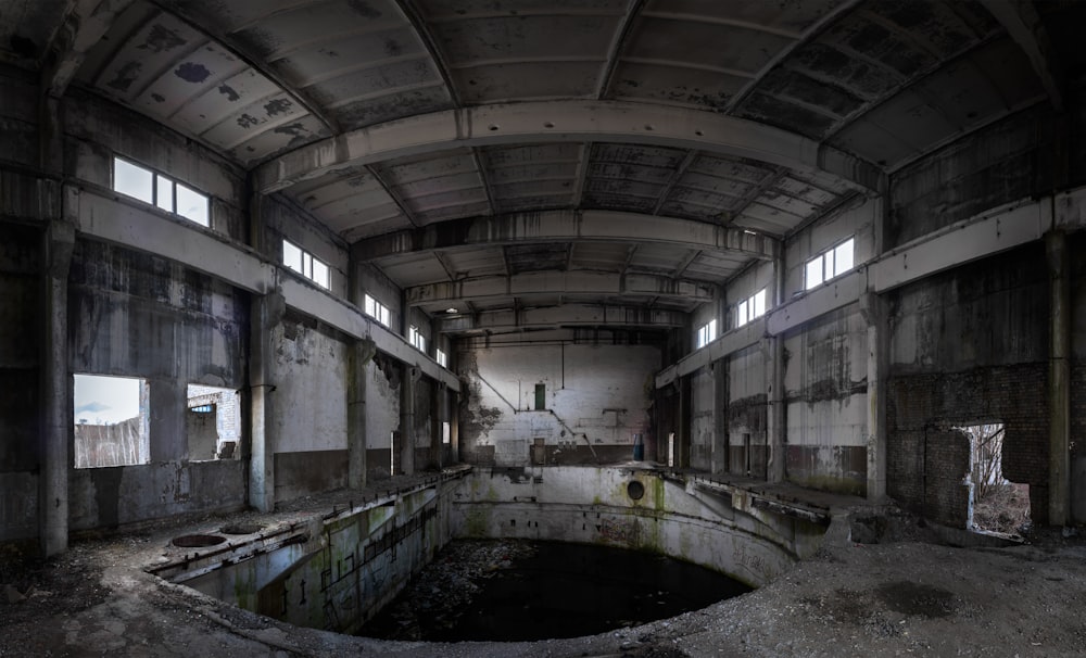 an abandoned building with a pool in the middle of it