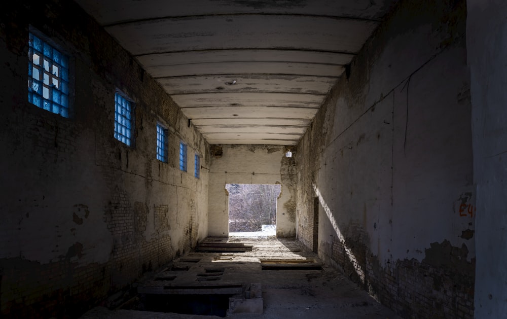 a long narrow hallway with blue windows in it