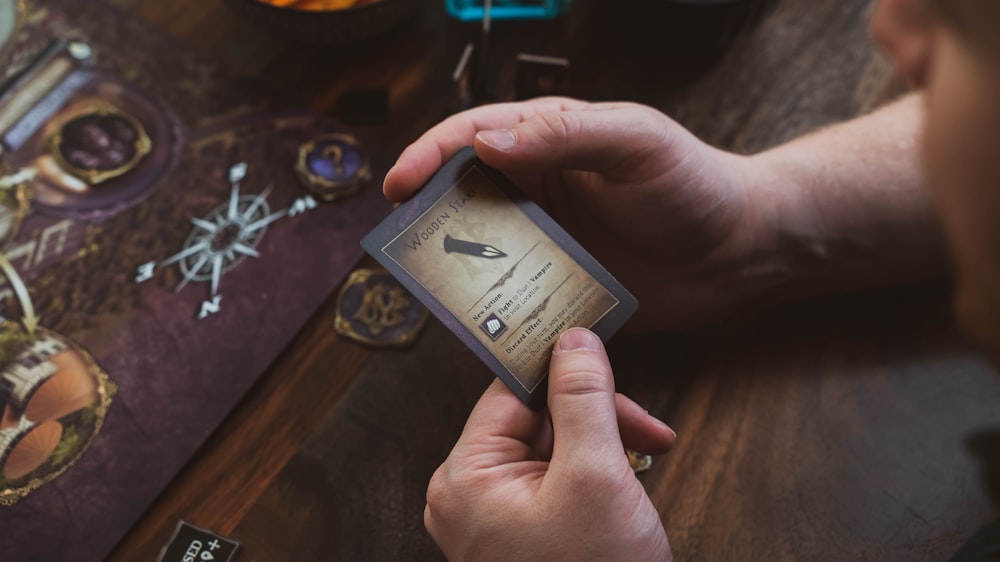 a person holding a card on top of a table