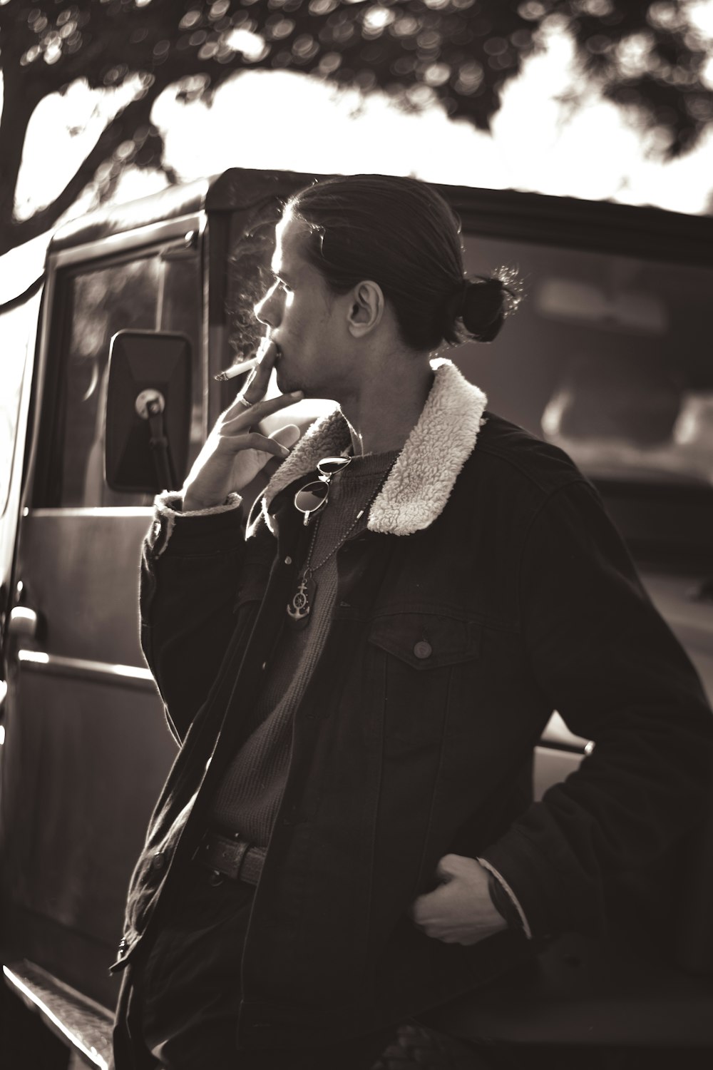 a woman standing next to a car talking on a cell phone