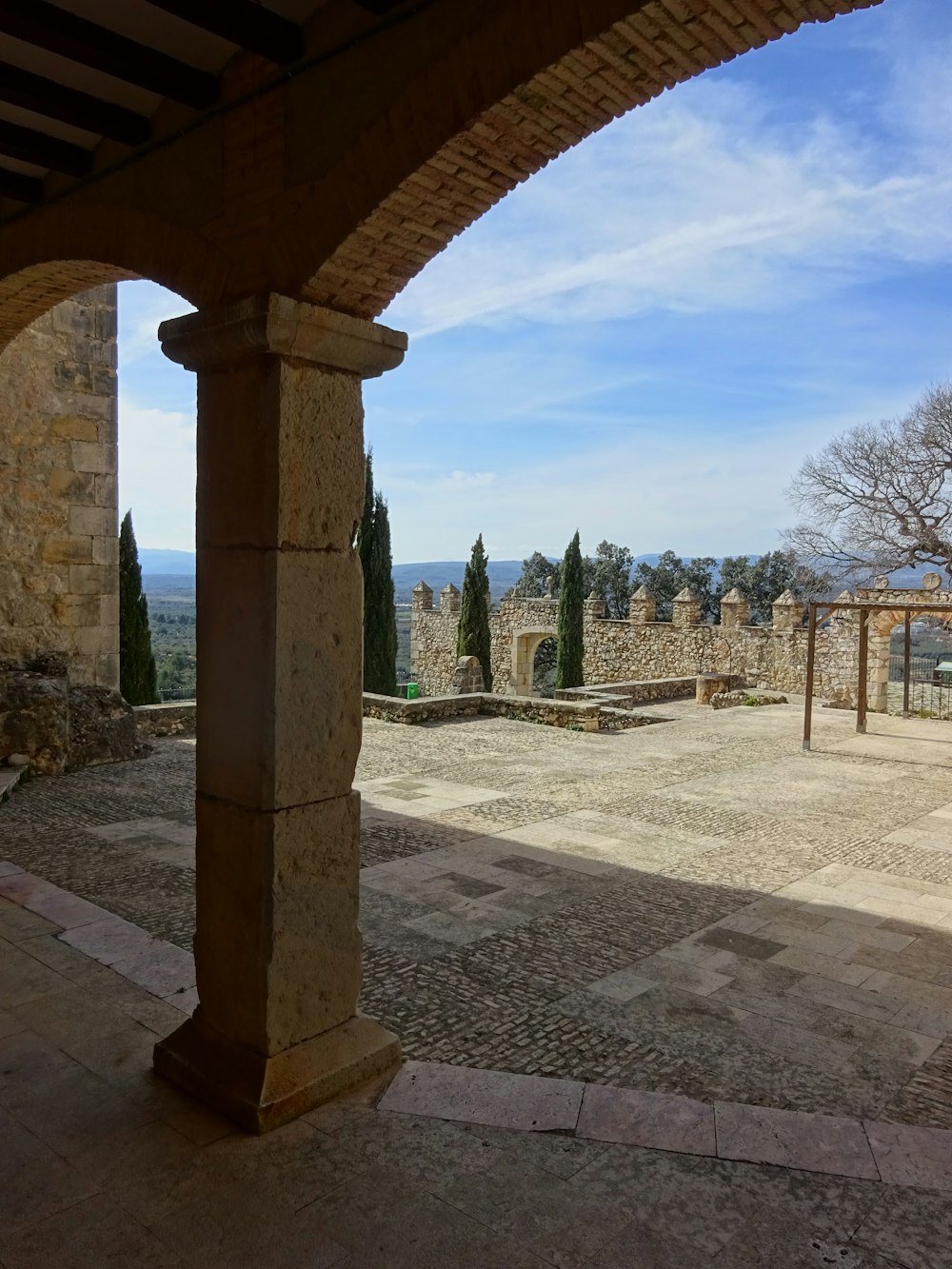 un edificio de piedra con columnas y una pasarela de piedra