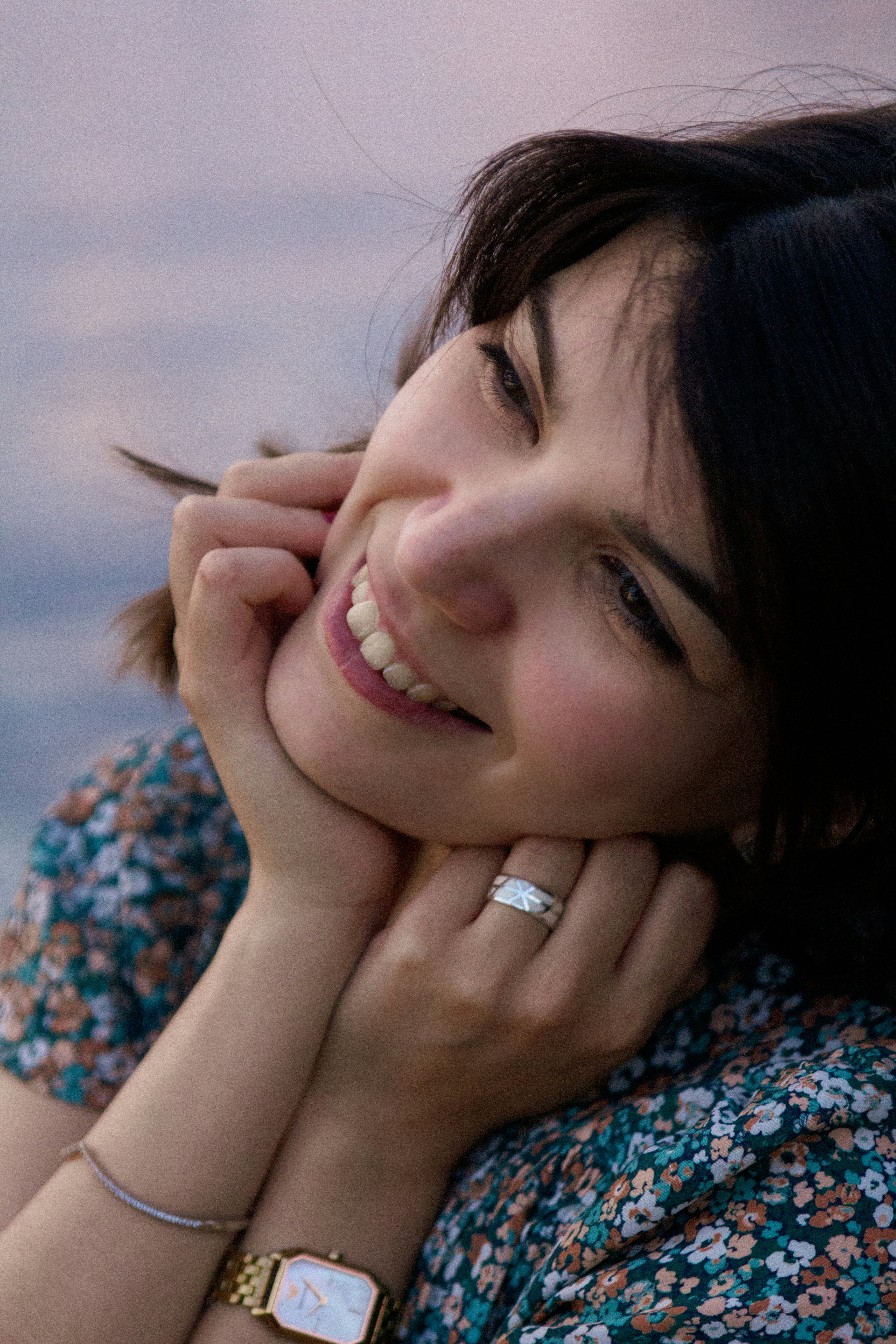 a woman smiling with her hand on her chin