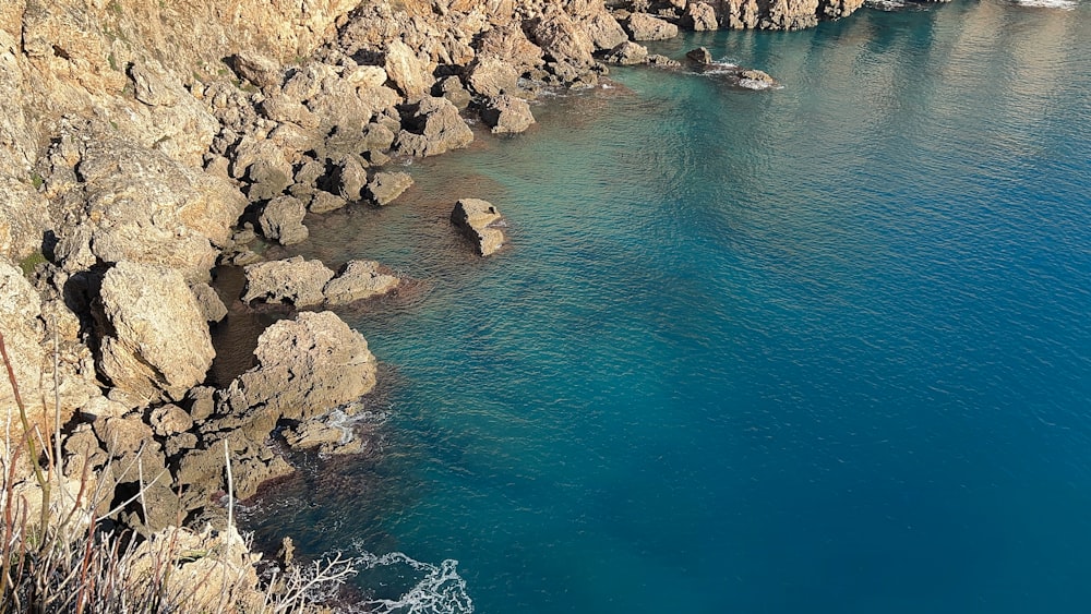 a body of water near a rocky cliff