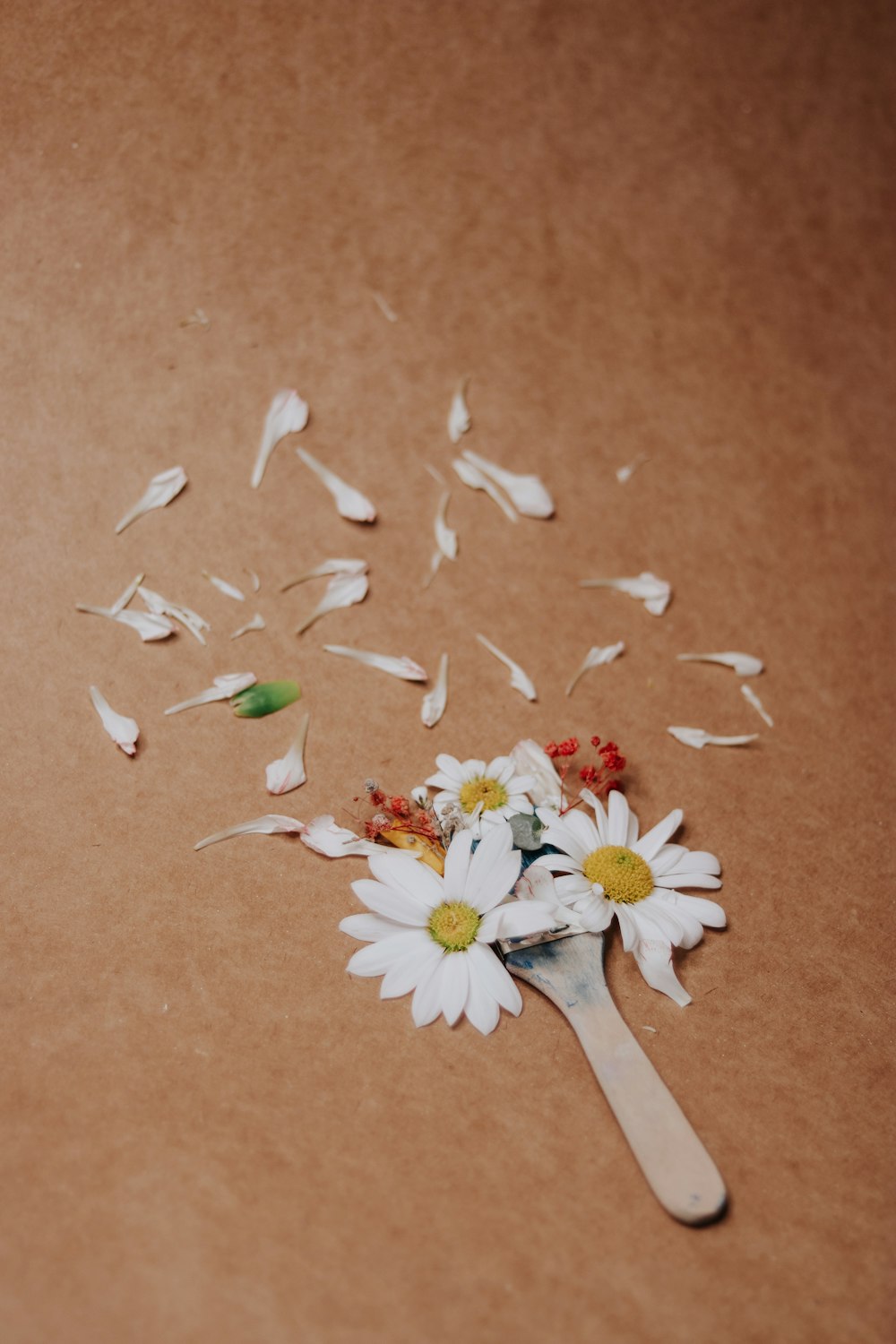 a wooden spoon filled with white flowers on top of a table