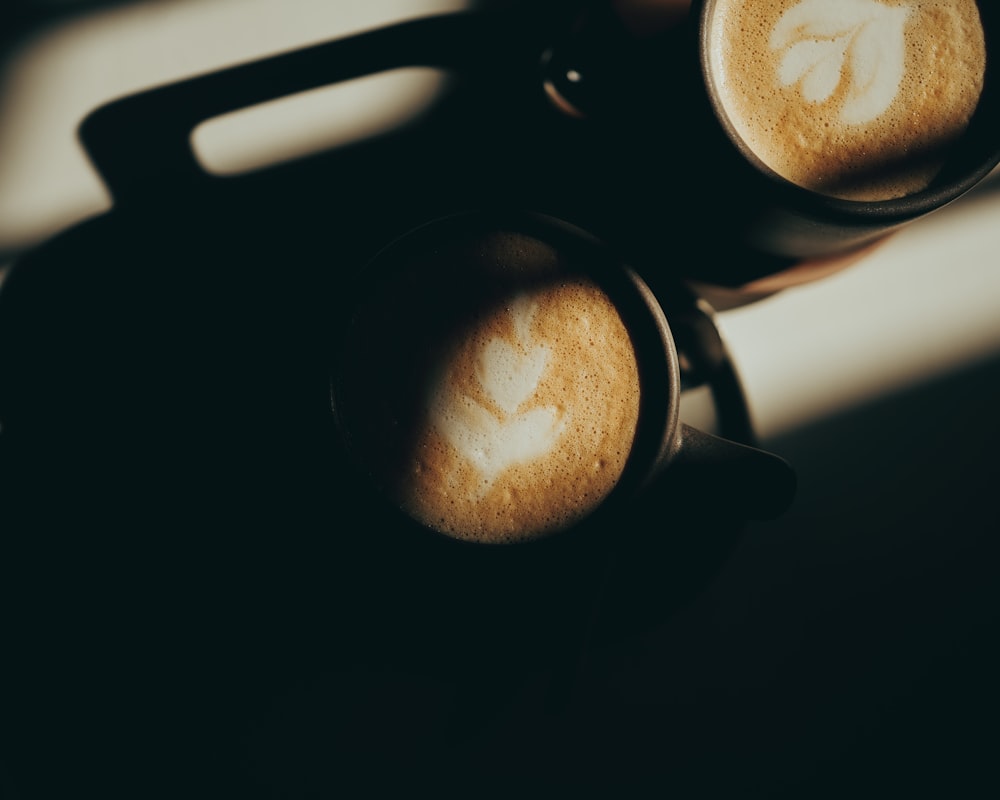 two cups of coffee sitting on top of a table