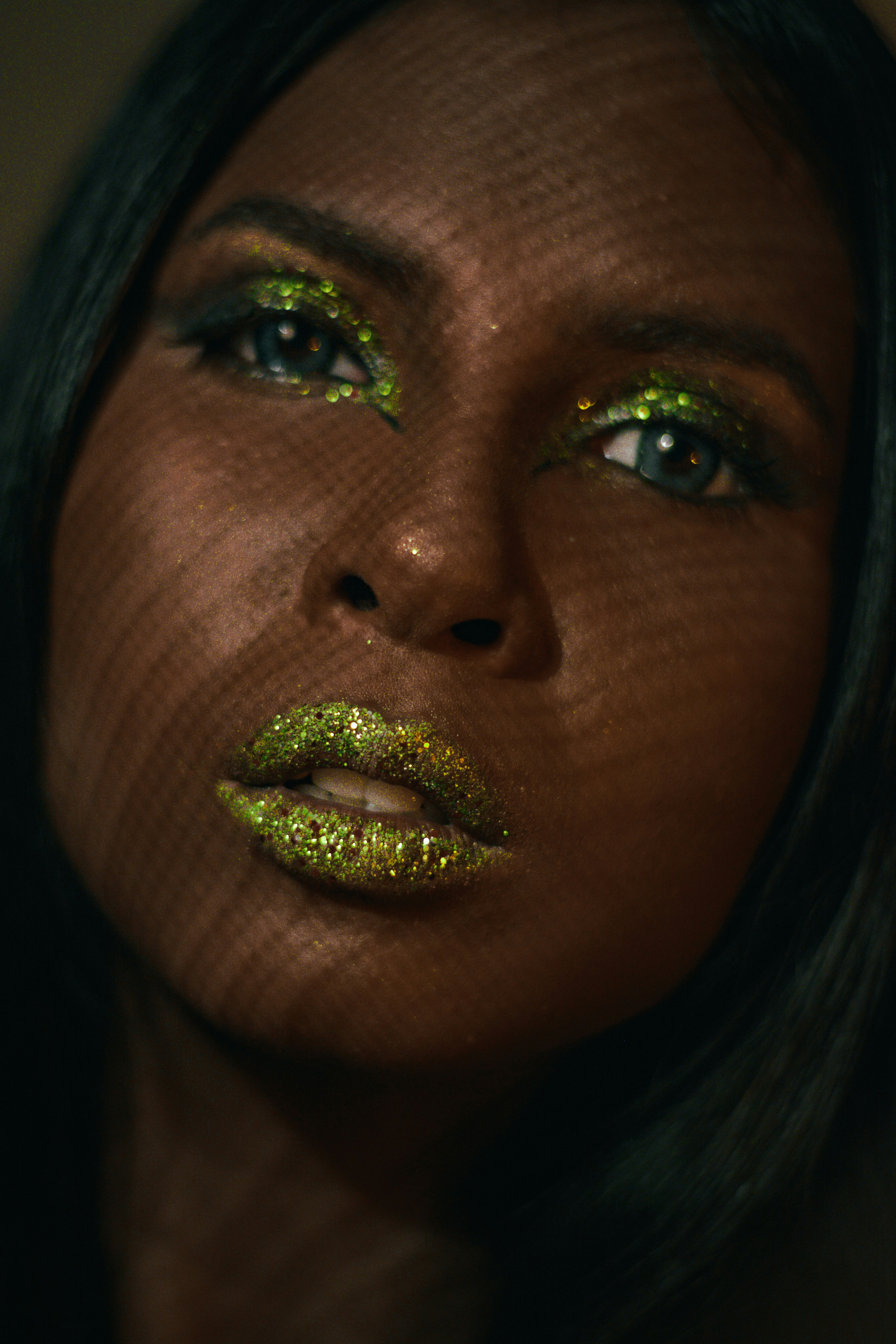 Una donna con glitter verde sulle labbra