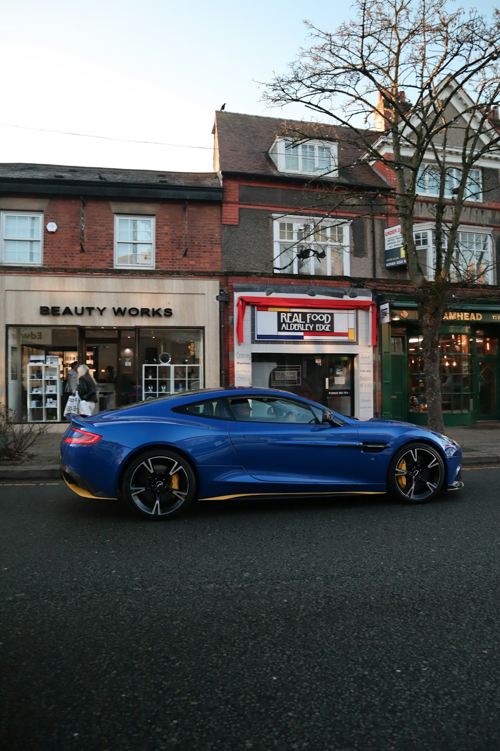a blue sports car parked in front of a store