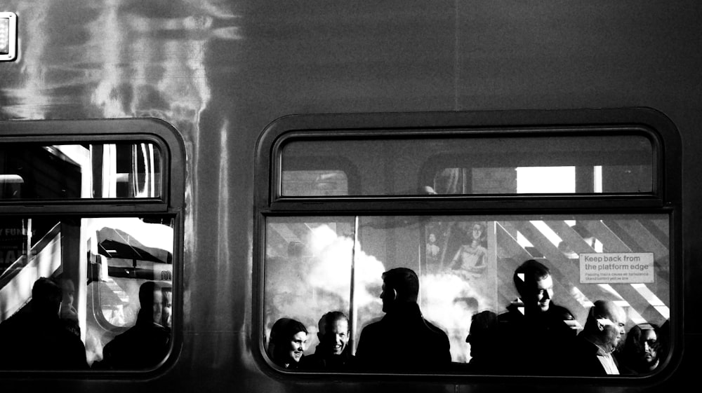 a black and white photo of people on a train