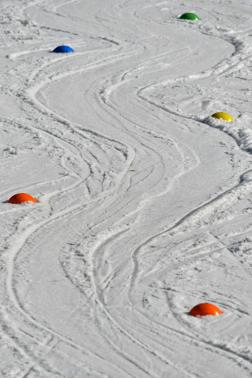 a snow covered ground with a bunch of different colored circles on it