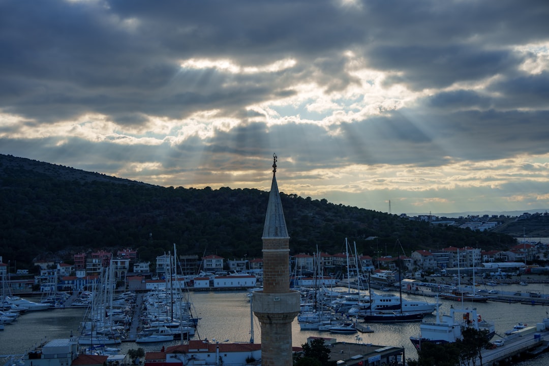 the sun is shining through the clouds over a harbor,