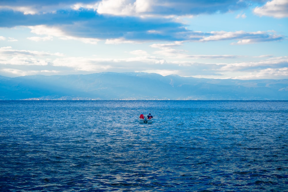 a couple of people in a small boat in the ocean