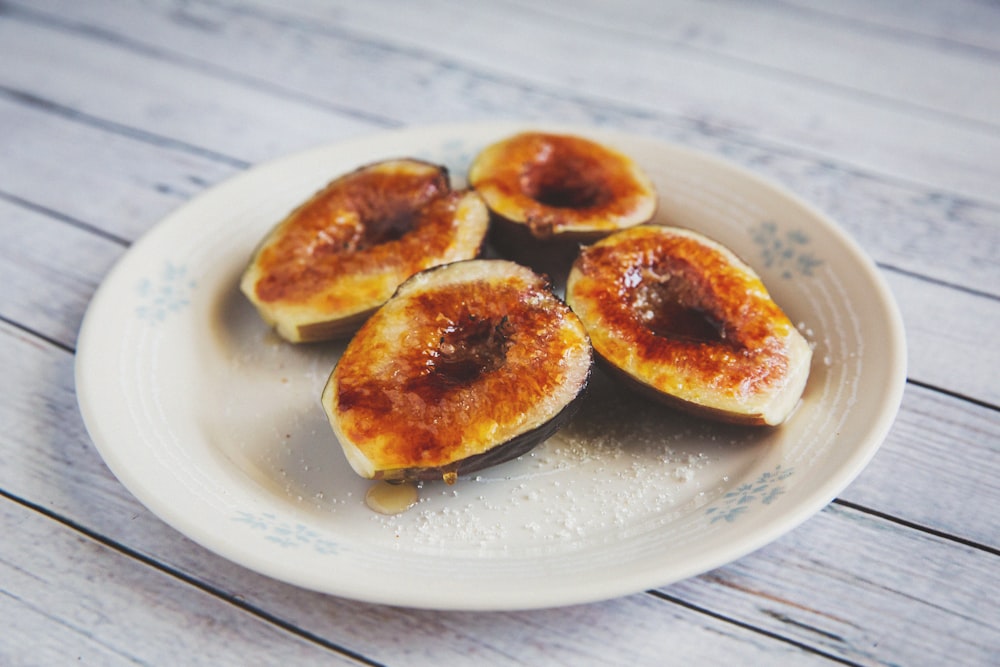 a white plate topped with sliced figs on top of a wooden table