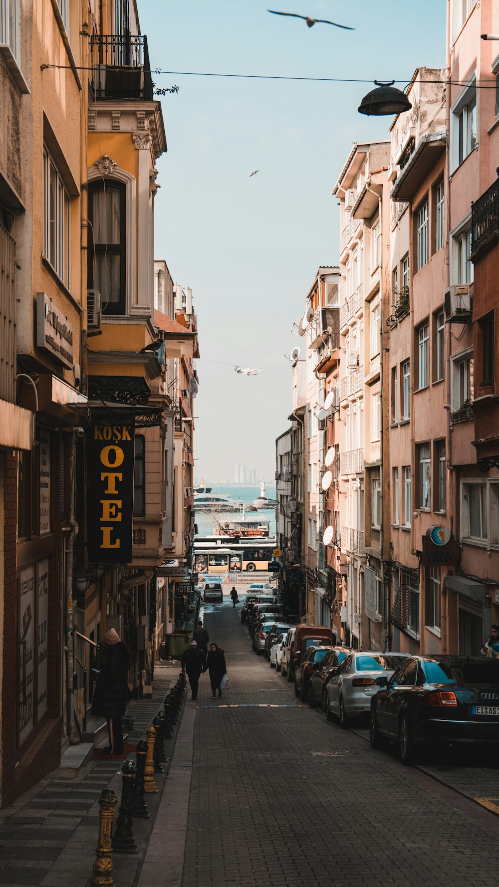 a city street lined with tall buildings and parked cars