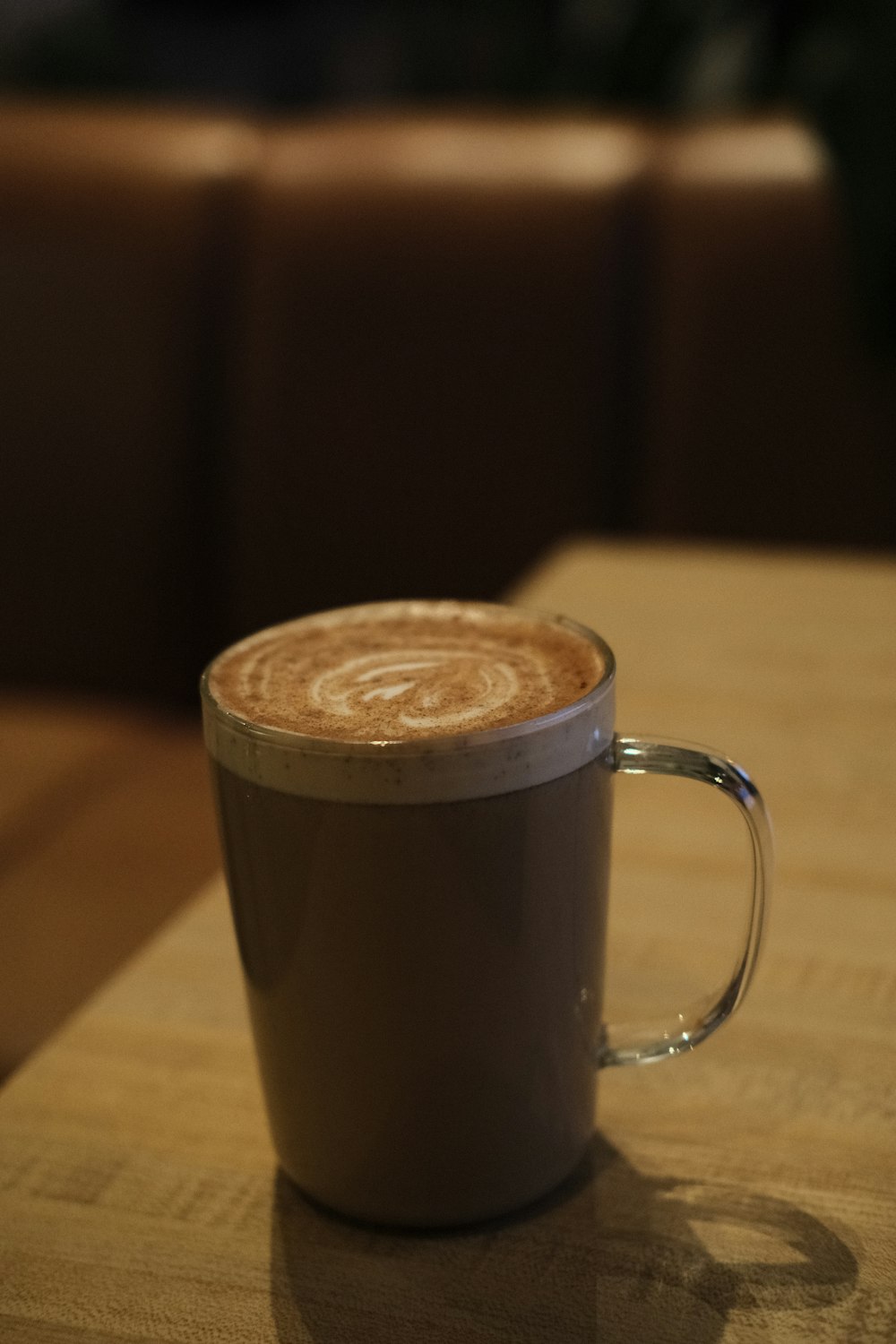 a cup of coffee sitting on top of a wooden table