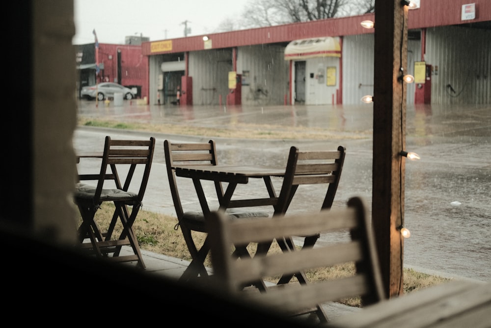 a row of wooden chairs sitting on top of a sidewalk