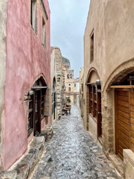 a narrow street with a few buildings on both sides