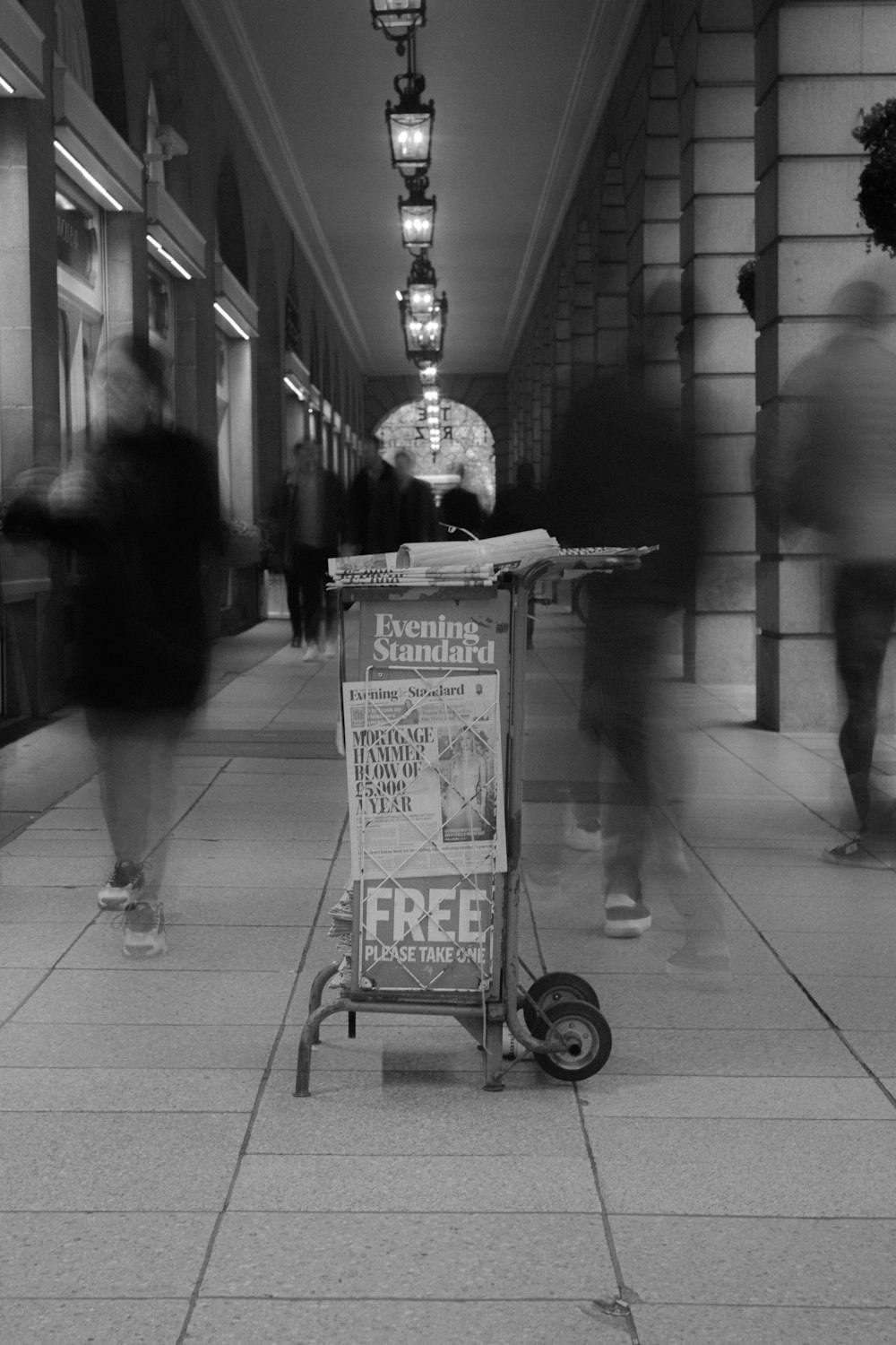 a black and white photo of a newspaper stand