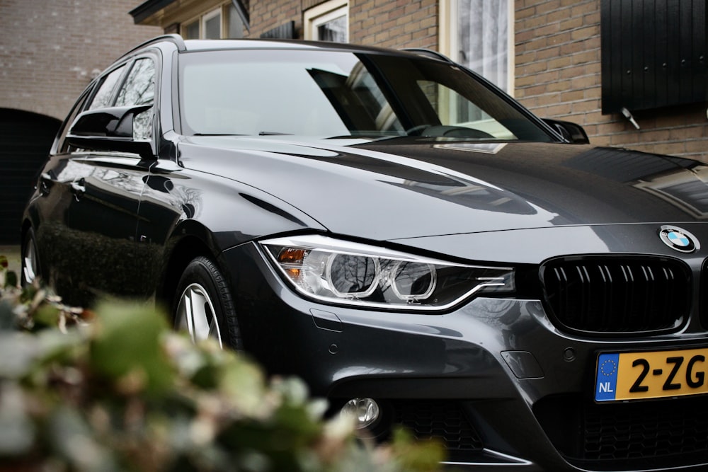 a black car parked in front of a brick building