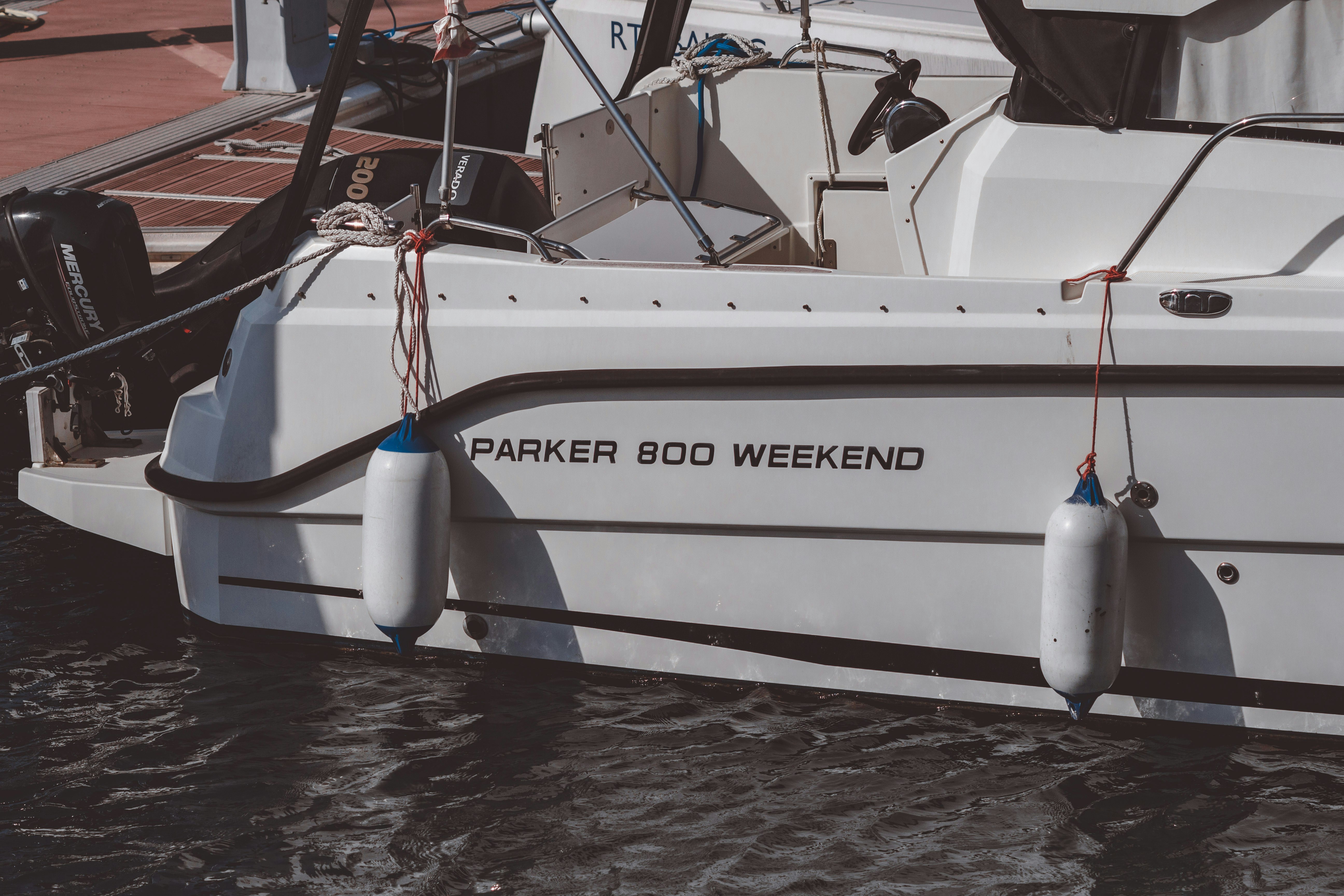 a white boat docked at a dock with other boats