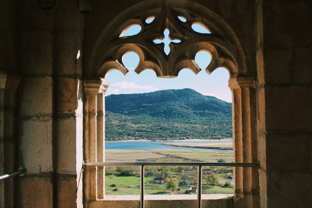 a window with a view of a valley and mountains