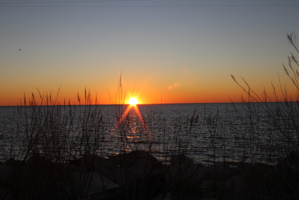 the sun is setting over a body of water