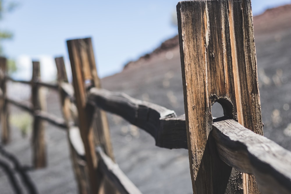 a close up of a wooden fence with a mountain in the background