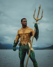 a man dressed as a mermaid holding a spear