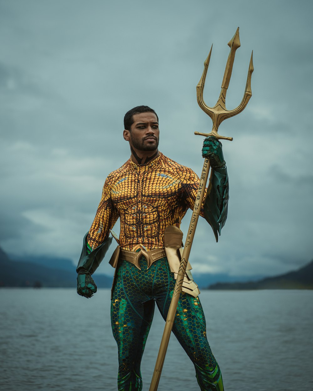 Un hombre vestido de sirena sosteniendo una lanza