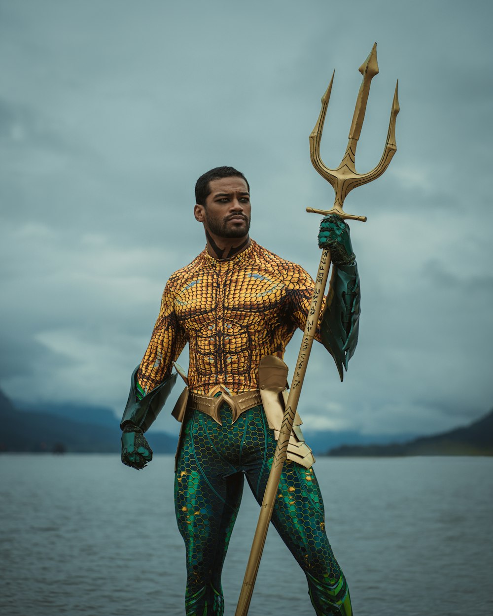 a man dressed as a mermaid holding a spear
