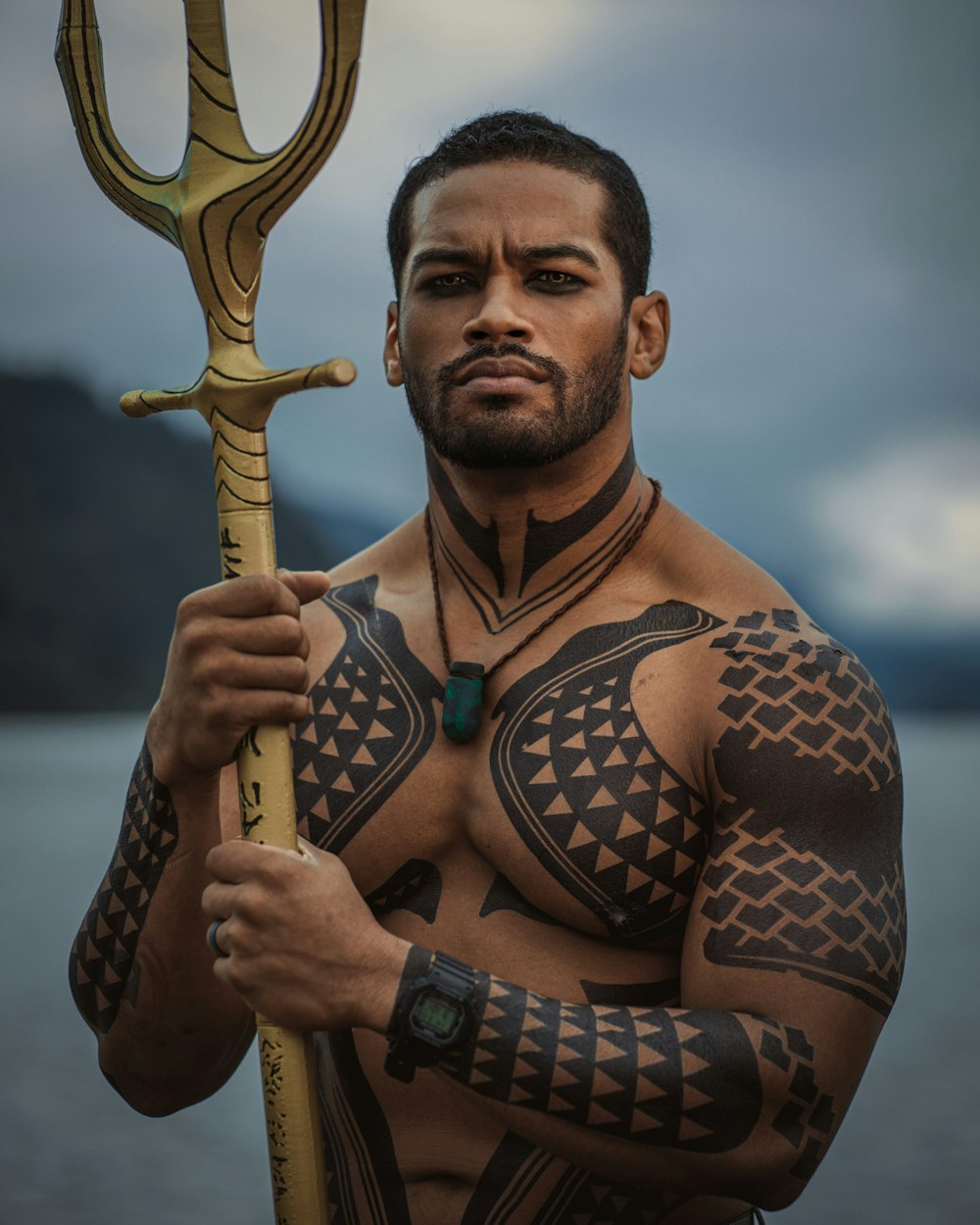um homem com uma tatuagem no peito segurando uma espada