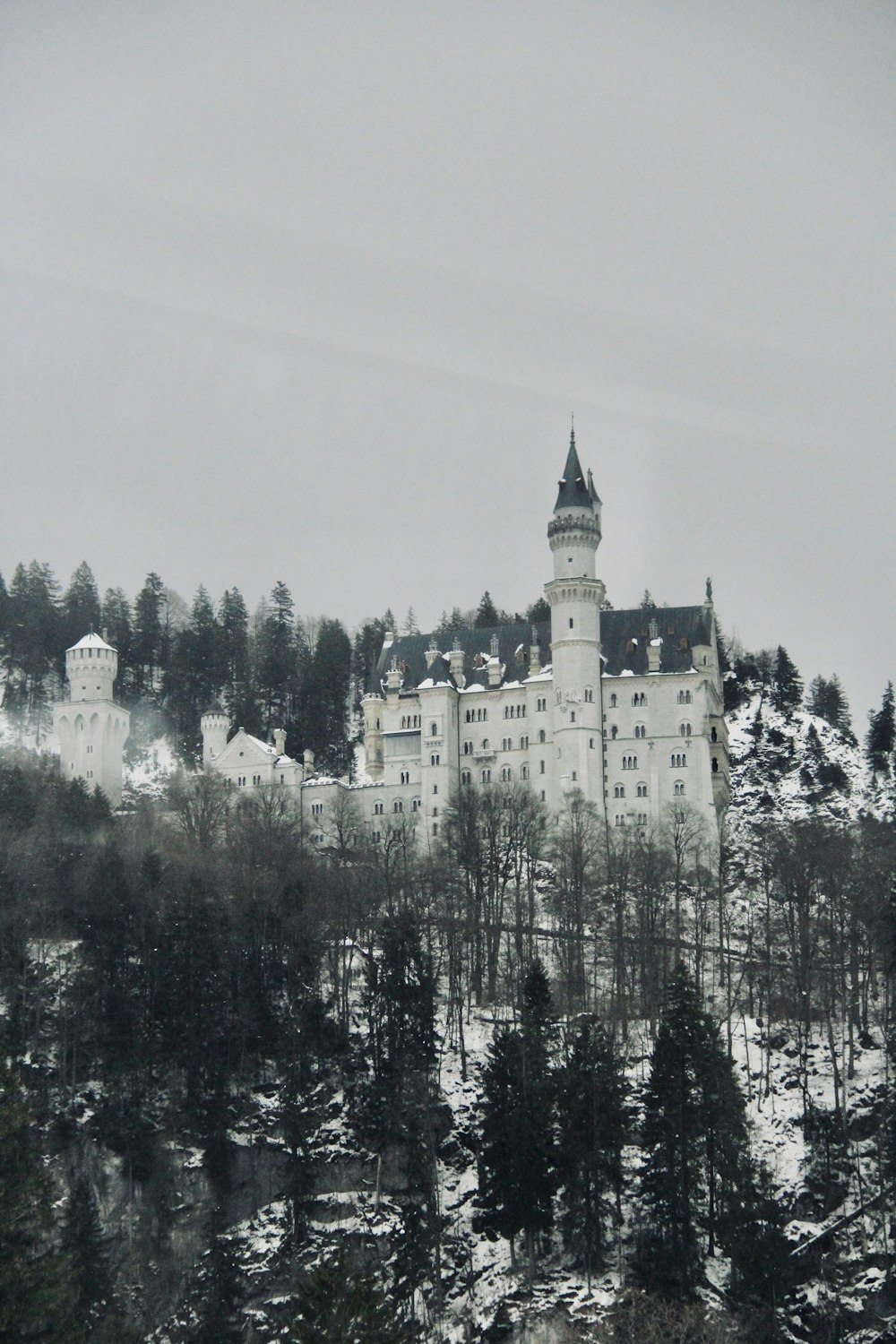 a large white building on top of a snow covered hill