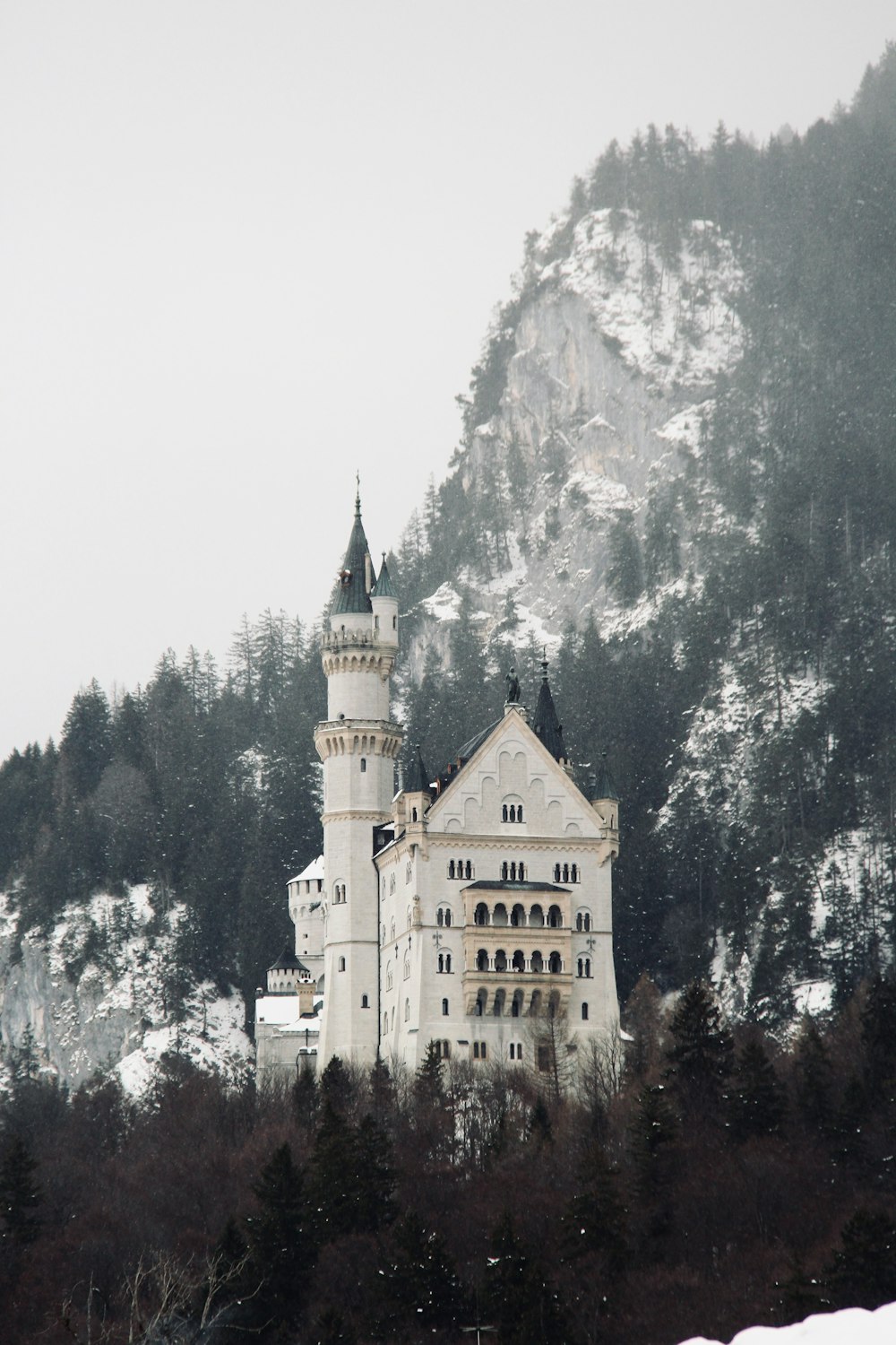 a large white castle sitting on top of a snow covered hill