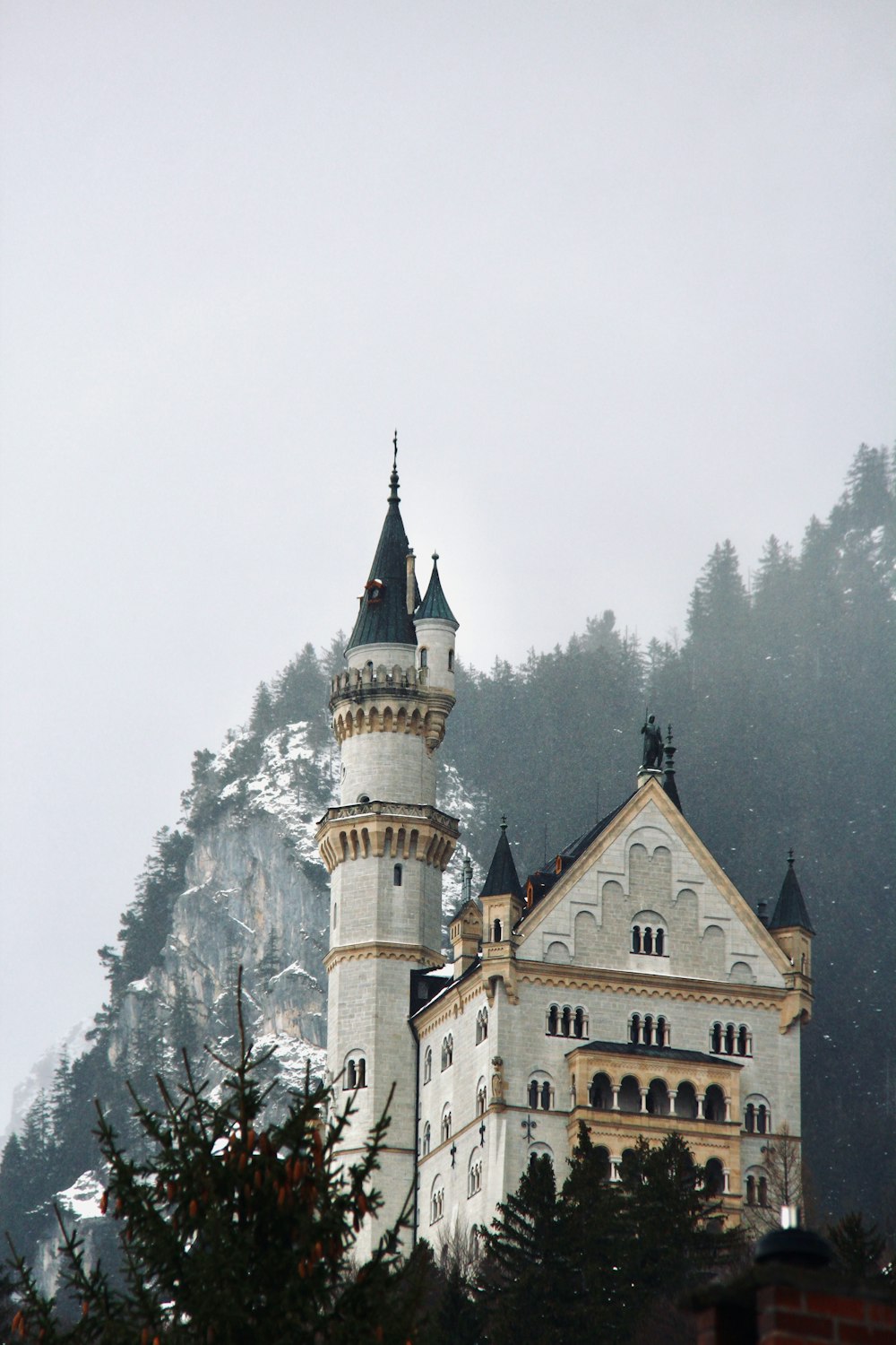 Un gran castillo blanco sentado en la cima de una montaña