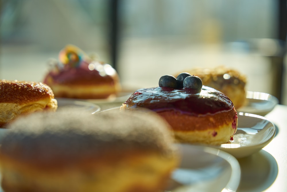 a row of donuts sitting on top of white plates