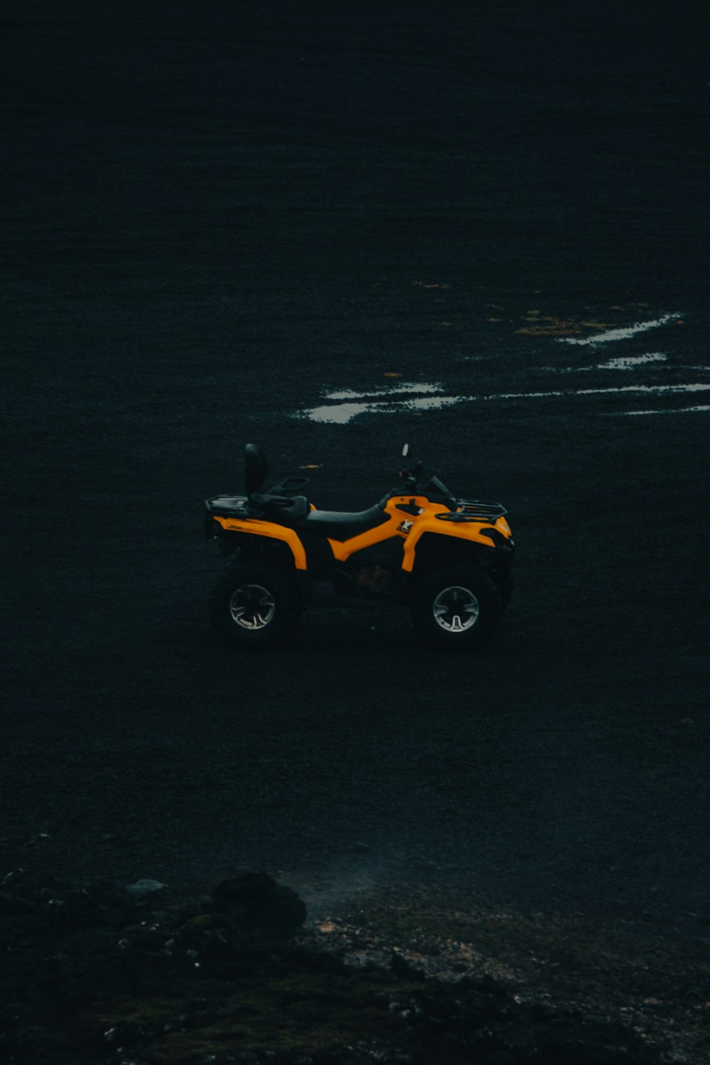 an orange and black four wheeler parked in a parking lot