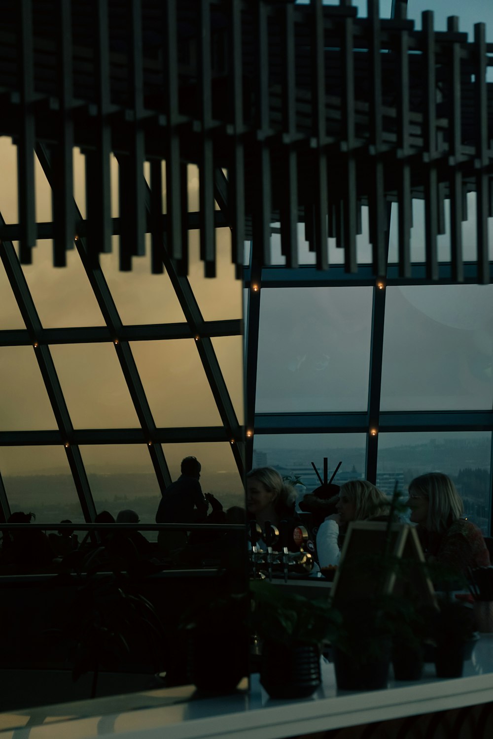 a group of people sitting at a table next to a window