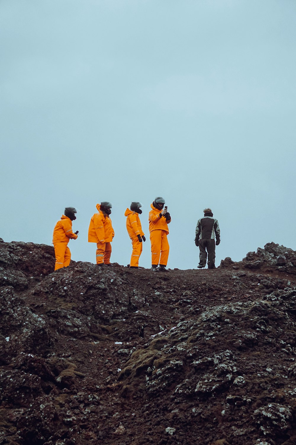 a group of people standing on top of a rocky hill