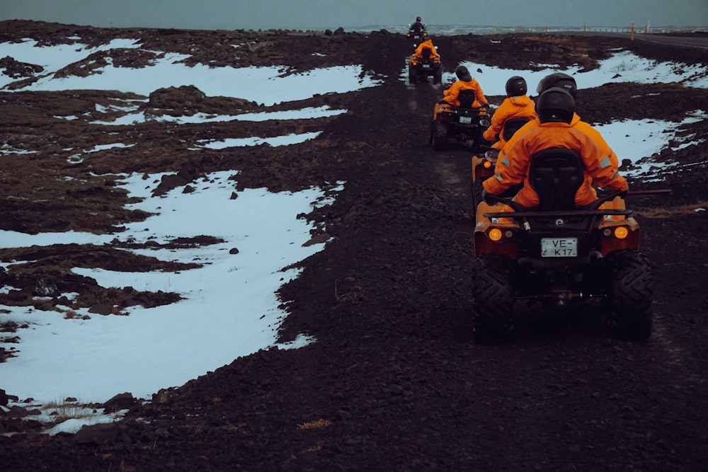 a group of people riding on the back of four wheelers