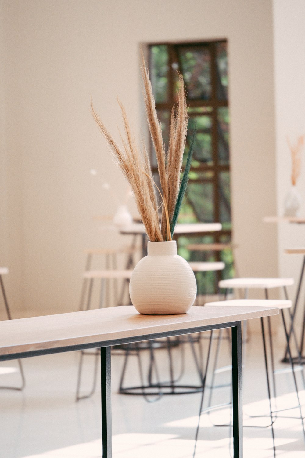 a table with a vase with a plant in it