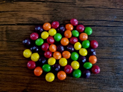 A colorful assortment of homemade candy pieces arranged on a rustic wooden board.