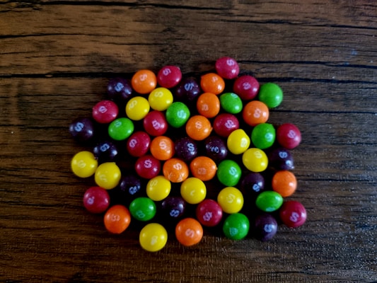 Colorful freeze-dried candiez scattered artistically on a wooden table.