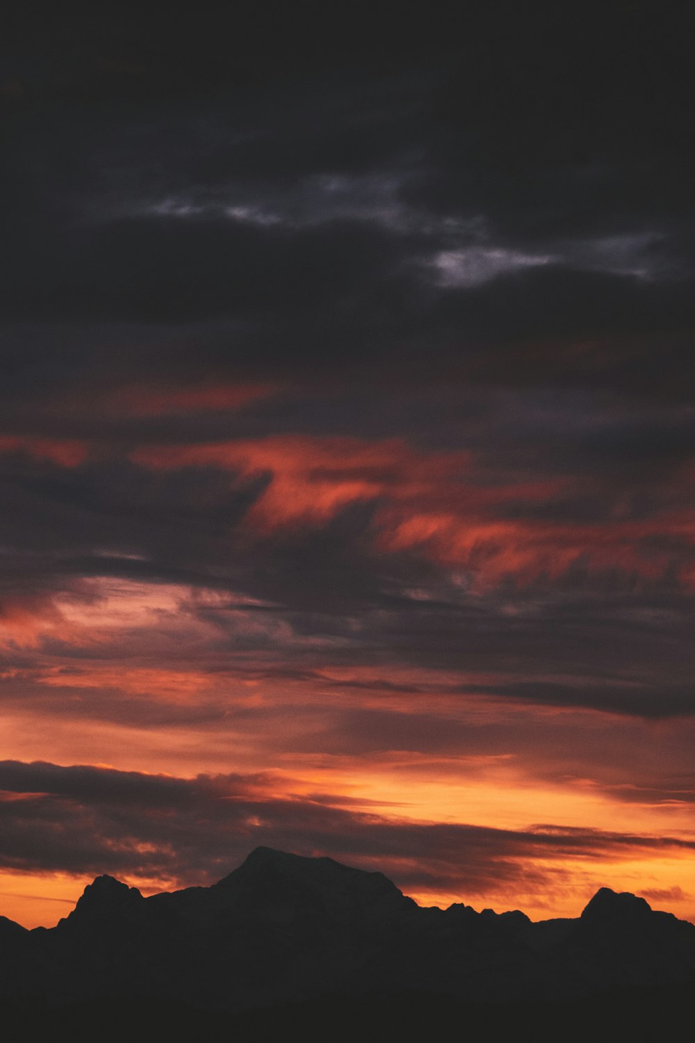 a plane flying in the sky with a sunset in the background