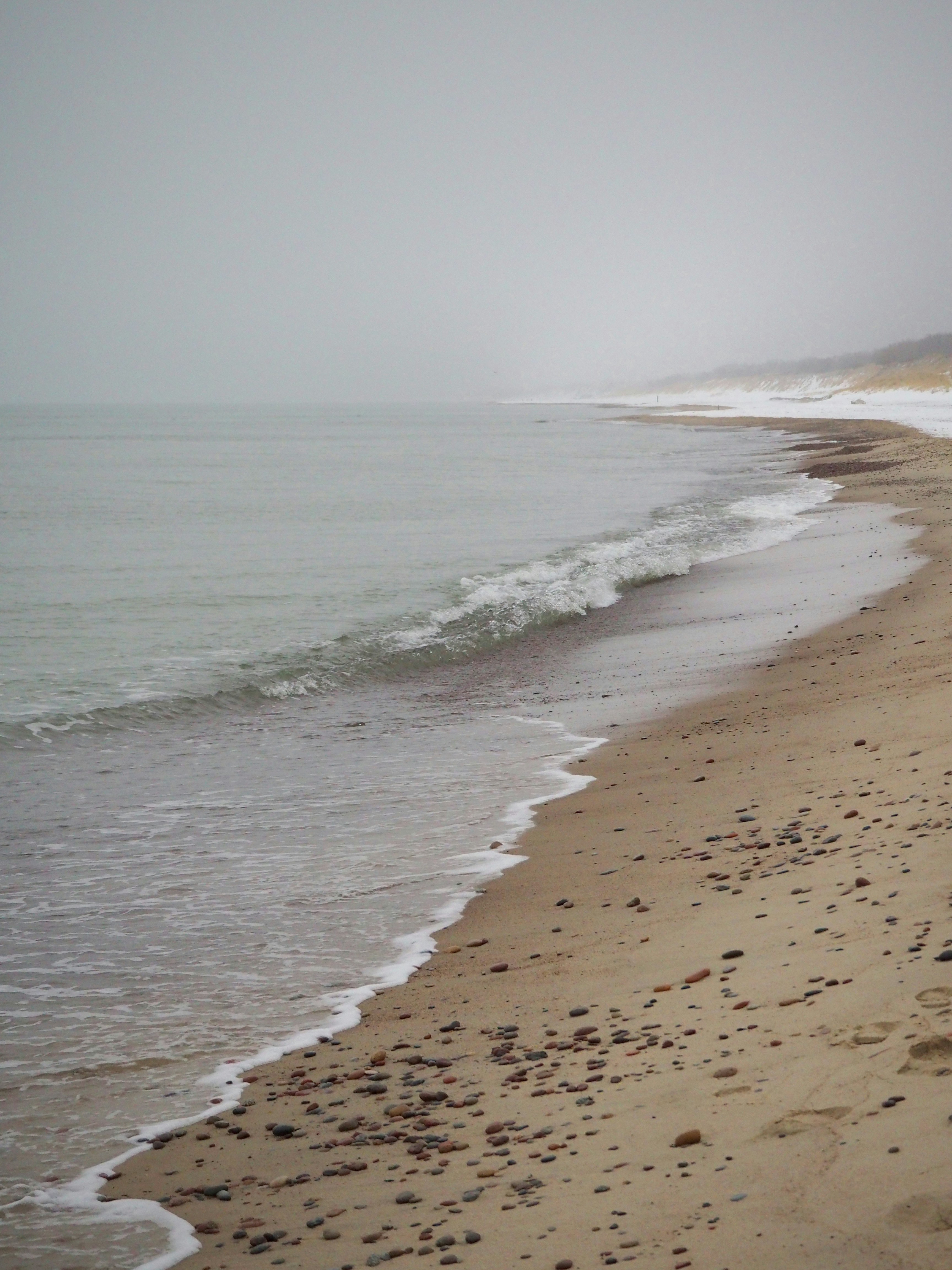 a sandy beach with waves coming in to shore