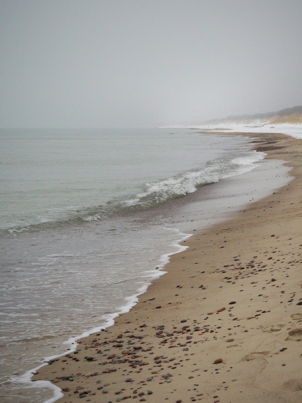 a sandy beach with waves coming in to shore