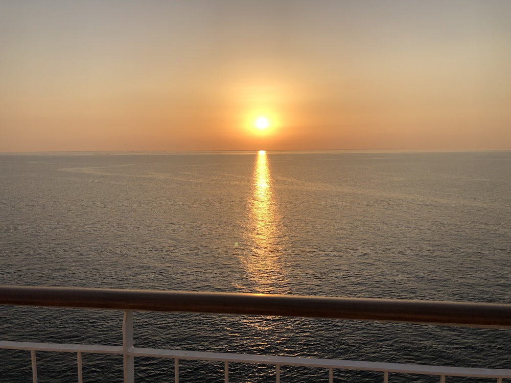 the sun is setting over the ocean as seen from a cruise ship