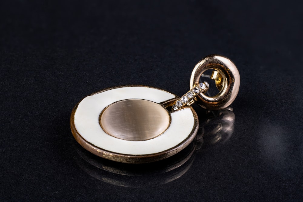 a close up of a gold and white object on a black surface