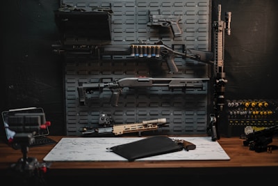 a table with a gun, rifle, and other items on it